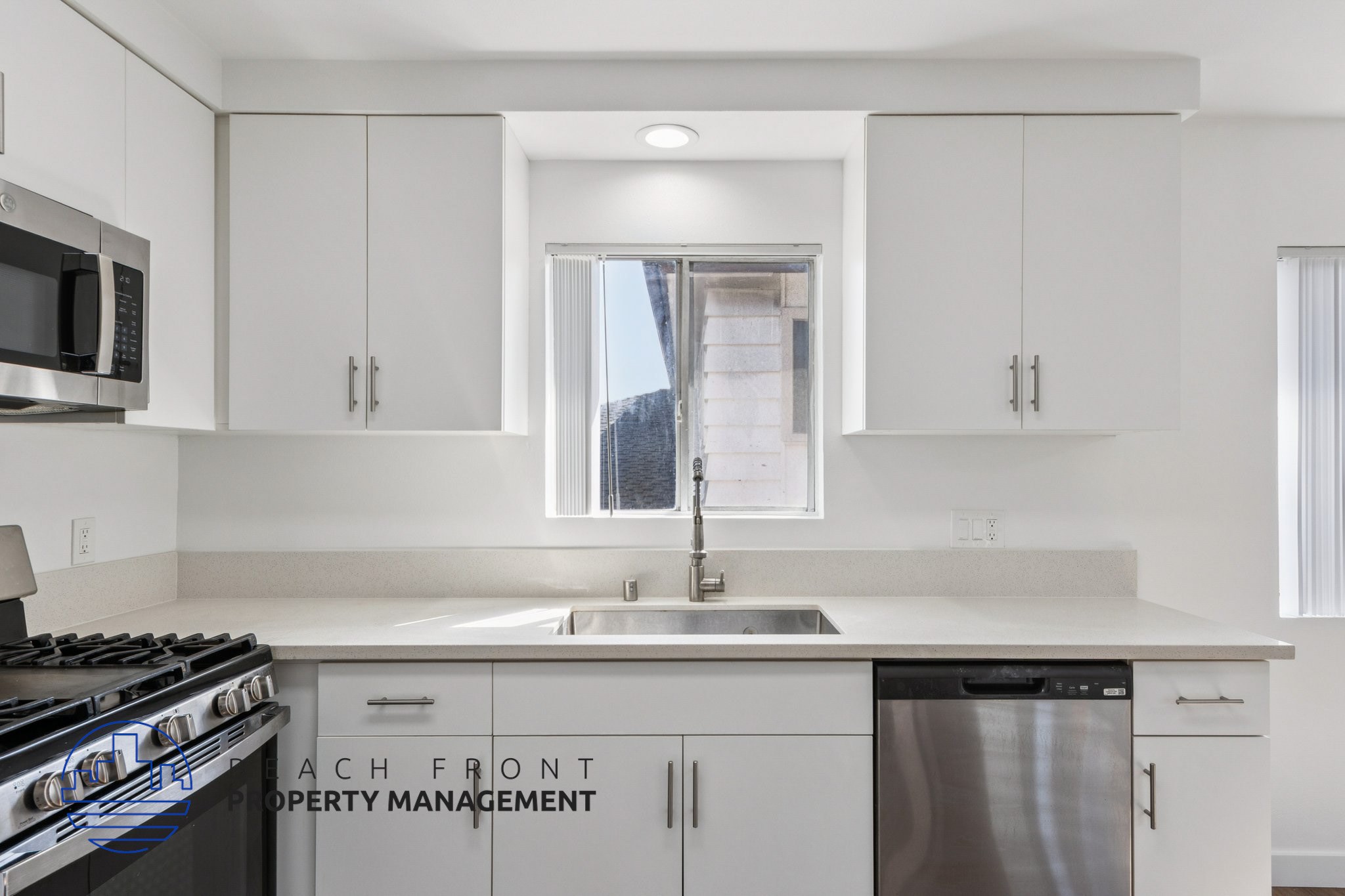 A kitchen with white cabinets and a stove top oven.